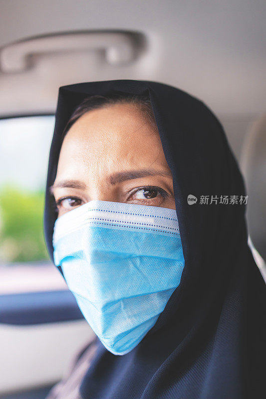 一名阿拉伯妇女戴着口罩驾驶的肖像- COVID-19系列